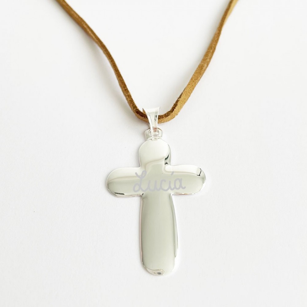 Colgante de cruz de plata brillante grabada con el nombre Lucia sobre un cordón de cuero marrón.