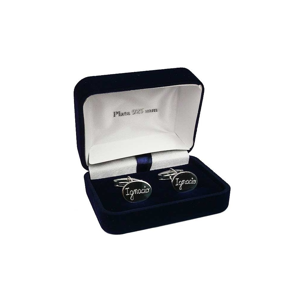 Par de gemelos redondos de plata personalizados con el nombre grabado en cursiva, presentados en un estuche de joyería azul marino.