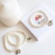 Pulseras de perlas con medalla y angel para invitados
