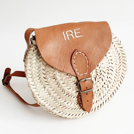 Bolso con iniciales redondo de rafia y solapa de cuero