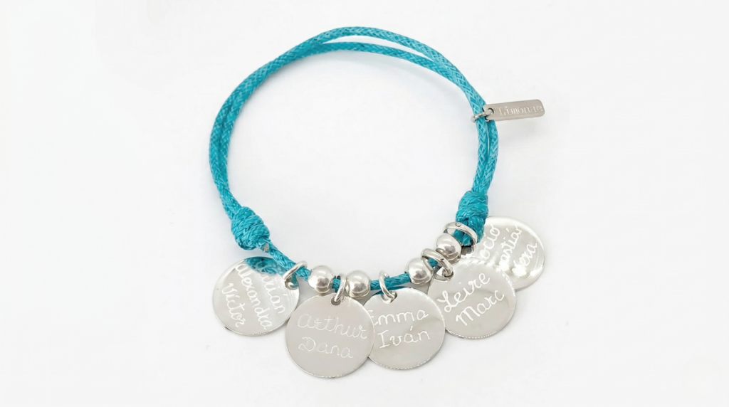 Pulsera ajustable en color turquesa con cinco medallas de plata redondas grabadas con los nombres de los alumnos como regalo de fin de curso para una profesora.