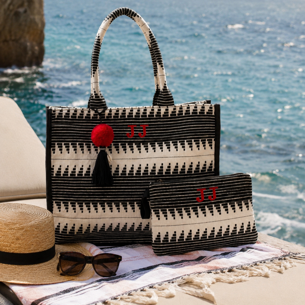 Bolsa de playa personalizada con iniciales y neceser a juego junto al mar.